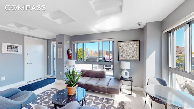 living room with tile patterned floors, a view of city, and baseboards