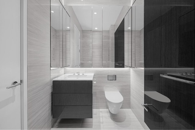 bathroom featuring tile patterned floors, vanity, toilet, and tile walls