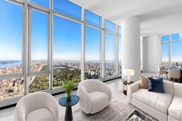 living room featuring plenty of natural light, expansive windows, and a water view