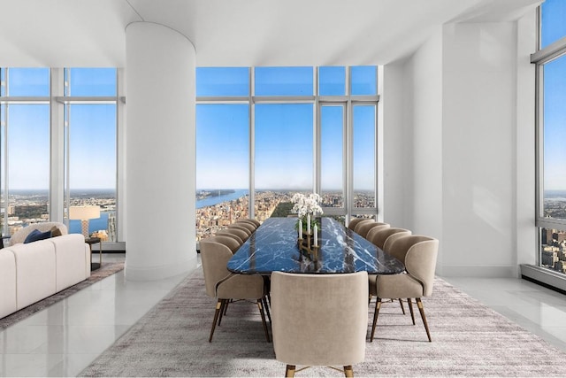 dining area with a wall of windows, decorative columns, a water view, and light tile patterned flooring