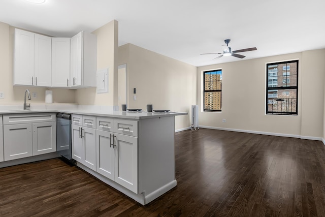 kitchen with dishwashing machine, a peninsula, a sink, white cabinetry, and light countertops