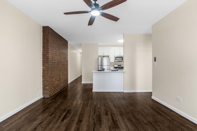 unfurnished living room featuring ceiling fan, dark wood-style flooring, and baseboards