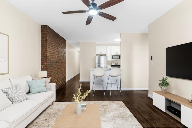 living room with ceiling fan and dark hardwood / wood-style flooring