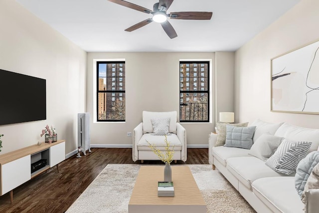 living room featuring ceiling fan and dark hardwood / wood-style flooring