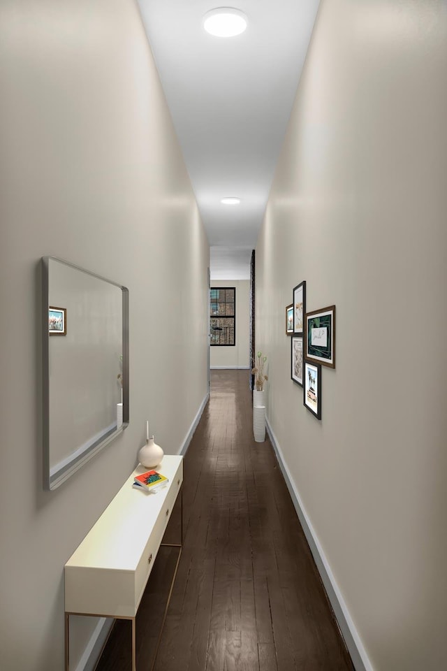 corridor with dark wood-style floors and baseboards