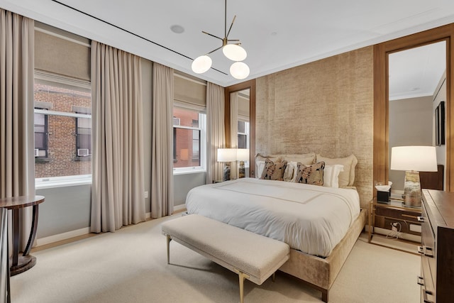 bedroom featuring baseboards, an inviting chandelier, light colored carpet, and crown molding