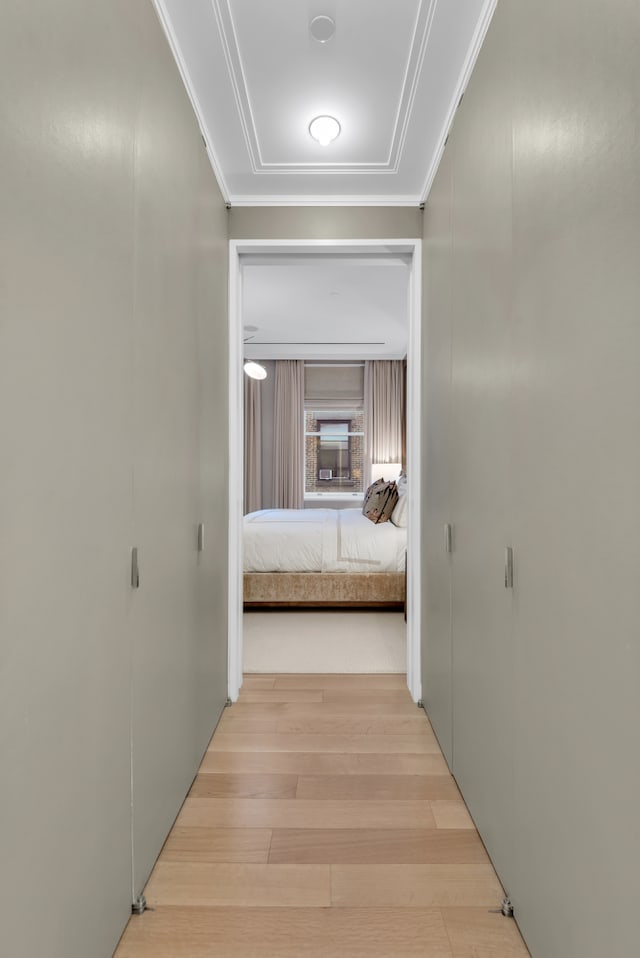 hallway with wood finished floors and ornamental molding