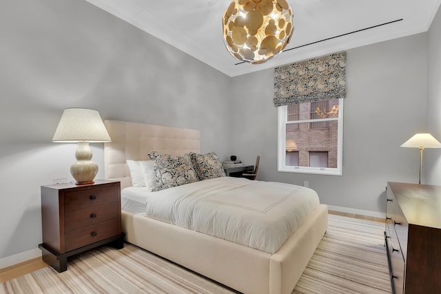 bedroom featuring baseboards, ornamental molding, and a chandelier