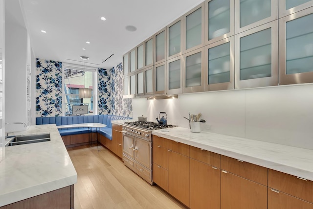 7 Harrison St Unit 3S, New York City, NY 10013 - kitchen with a sink, stainless steel gas stovetop, light wood-type flooring, glass insert cabinets, and wallpapered walls