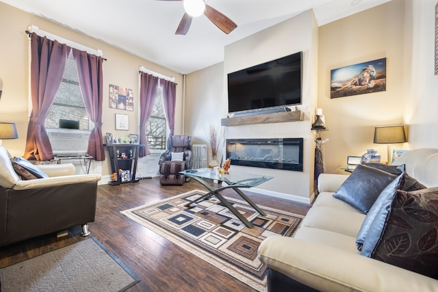 living room with dark wood-type flooring and ceiling fan