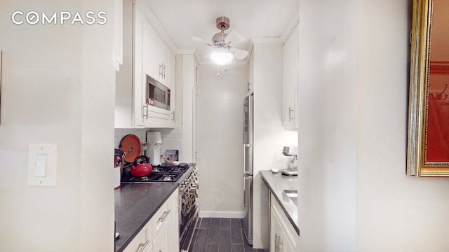 kitchen with tasteful backsplash, crown molding, dark hardwood / wood-style flooring, stainless steel appliances, and white cabinets