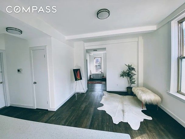 hall with dark wood-type flooring and beamed ceiling