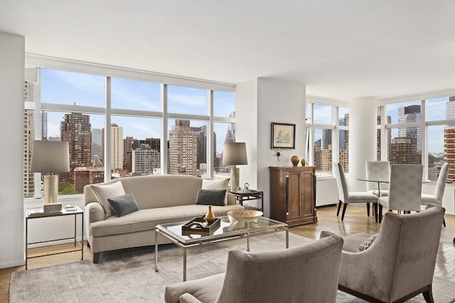 living room with floor to ceiling windows, a city view, and light wood finished floors