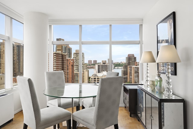 dining space with light parquet floors and a wall of windows