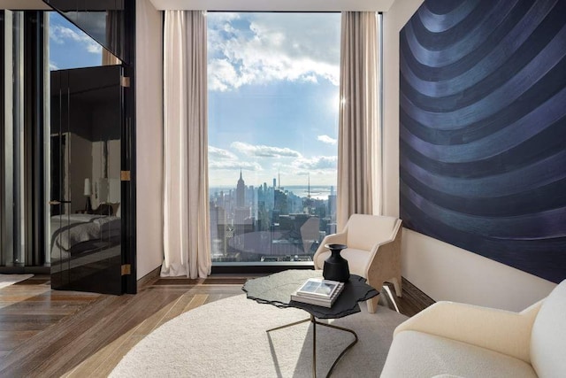 living area featuring a city view, wood finished floors, and expansive windows