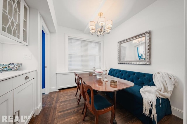 dining space with dark hardwood / wood-style floors, a notable chandelier, and breakfast area