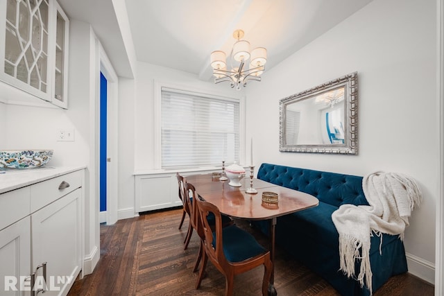 dining area featuring a chandelier, dark wood-style floors, breakfast area, and baseboards