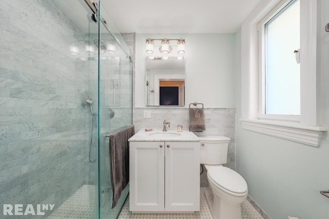 bathroom featuring vanity, a shower stall, toilet, and tile walls