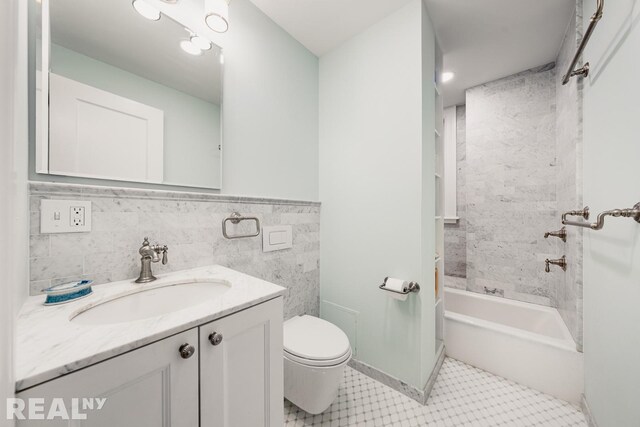 full bathroom with toilet, shower / washtub combination, tile walls, tile patterned flooring, and vanity