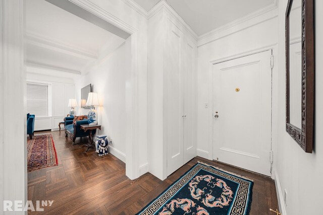 foyer with beamed ceiling and baseboards