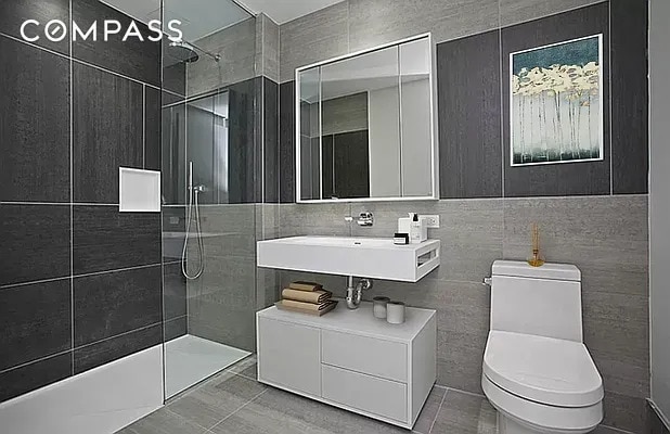 540 W 49th St Unit 406N/407N, New York City, NY 10019 - full bath with toilet, a walk in shower, tile walls, a sink, and tile patterned flooring