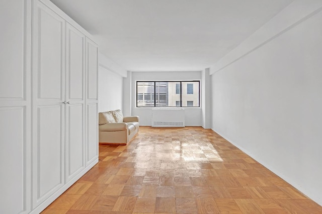 interior space featuring radiator heating unit and light parquet floors