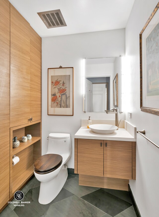 bathroom with vanity, toilet, and tile patterned flooring