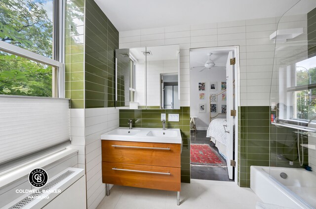 bathroom featuring tile walls, vanity, a washtub, ceiling fan, and tile patterned floors