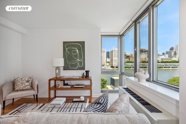 living area with expansive windows, a view of city, visible vents, and wood finished floors