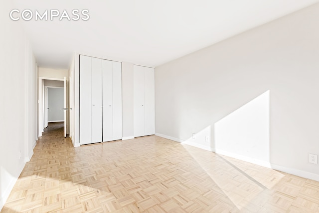 unfurnished bedroom featuring baseboards and multiple closets