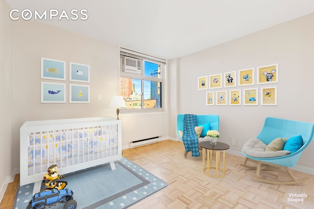 bedroom with baseboards, baseboard heating, and a crib