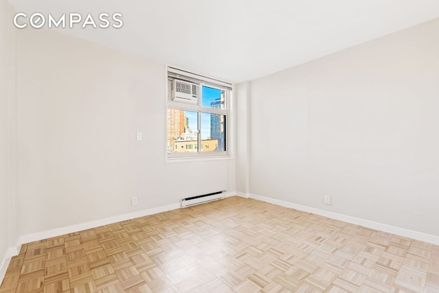 spare room with light parquet floors and a baseboard radiator