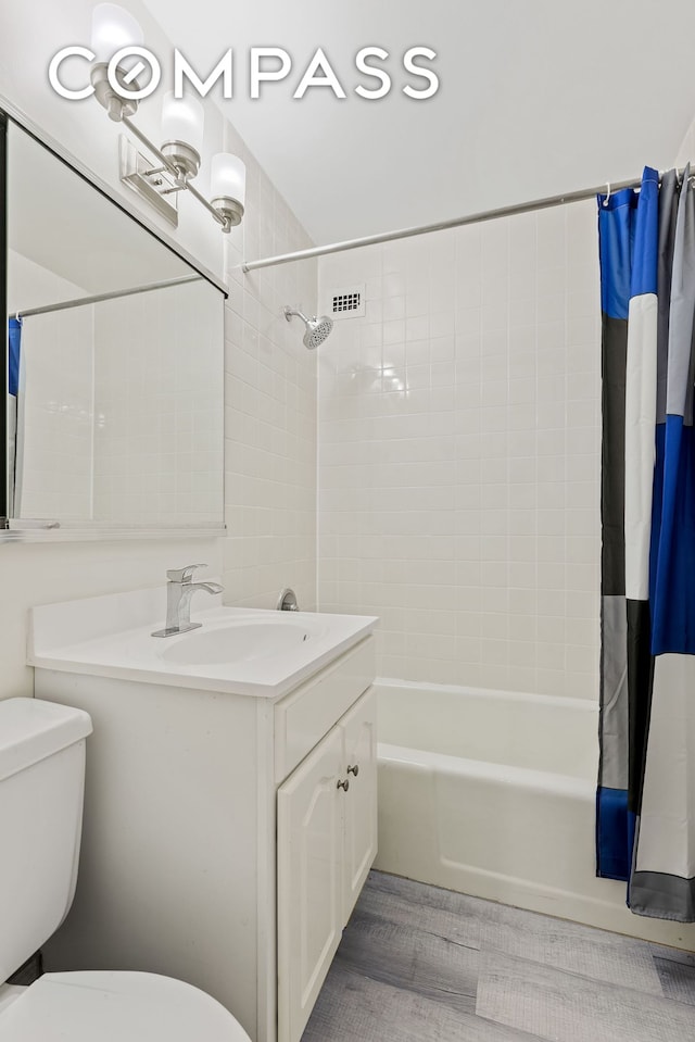 full bathroom featuring vanity, toilet, wood finished floors, and shower / bath combo with shower curtain