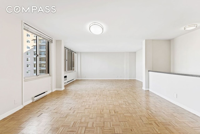 spare room featuring light parquet floors and a baseboard heating unit