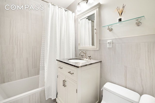 full bathroom with toilet, tile walls, vanity, and tiled shower / bath