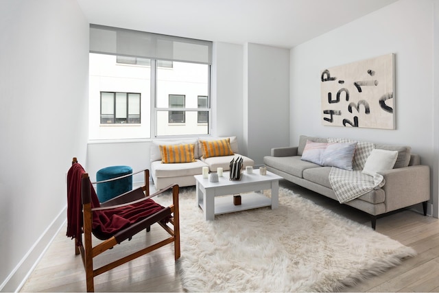 living area with hardwood / wood-style flooring and baseboards