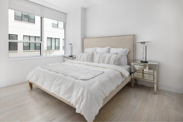 bedroom featuring baseboards and light wood finished floors