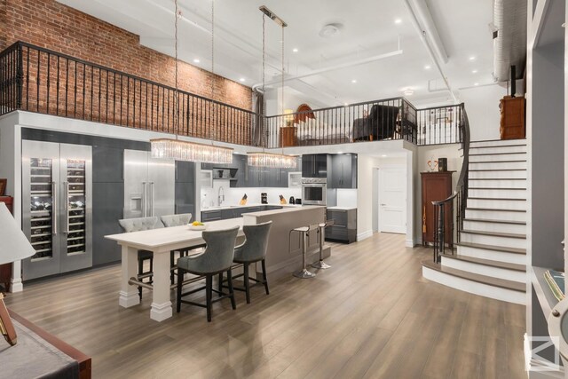 kitchen with a kitchen bar, a center island, dark hardwood / wood-style flooring, oven, and a high ceiling