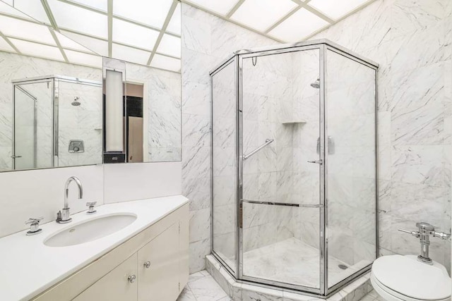 bathroom with a shower with door, vanity, and toilet