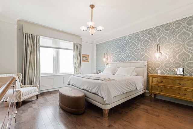 bedroom with wallpapered walls, an inviting chandelier, wood finished floors, and ornamental molding