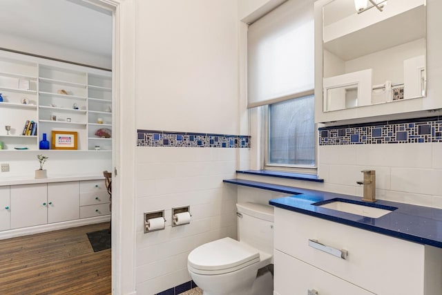 bathroom with vanity, tile walls, toilet, and wood finished floors