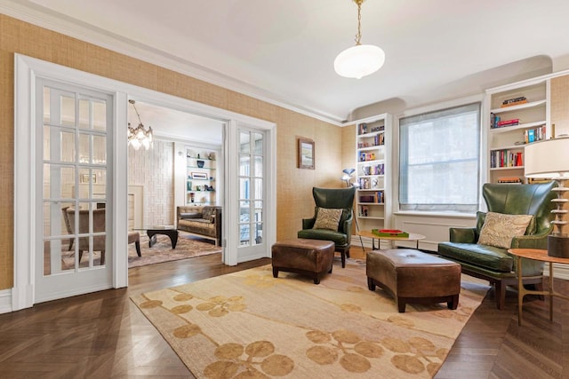 living area featuring a notable chandelier, ornamental molding, and wallpapered walls