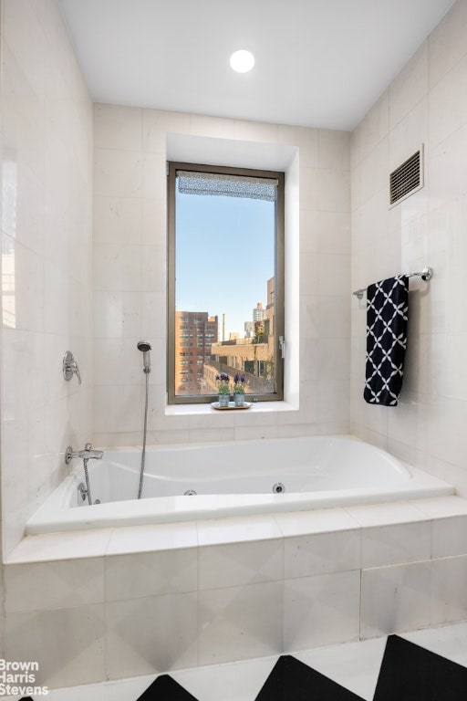 bathroom featuring tile walls and a relaxing tiled tub