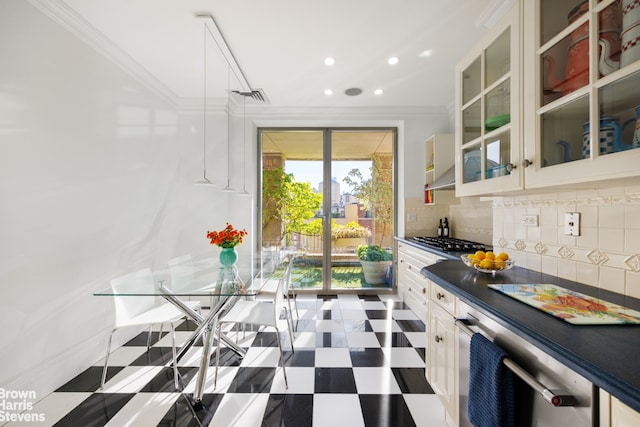 kitchen featuring stainless steel gas stovetop, crown molding, white cabinets, and decorative backsplash