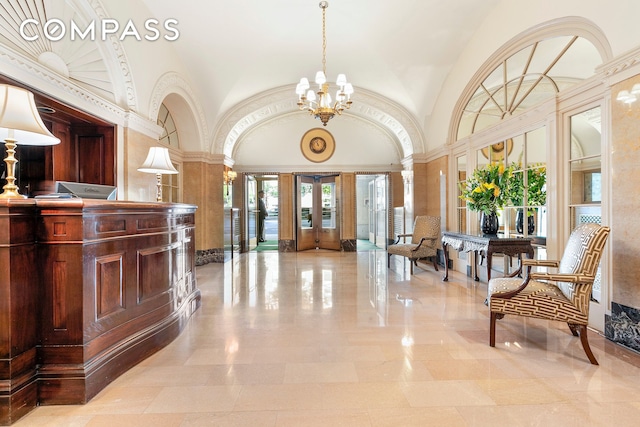 reception with an inviting chandelier, decorative columns, and french doors