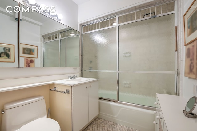 bathroom with enclosed tub / shower combo, tile patterned floors, toilet, and vanity