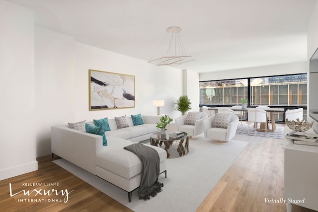 living area with baseboards and wood finished floors