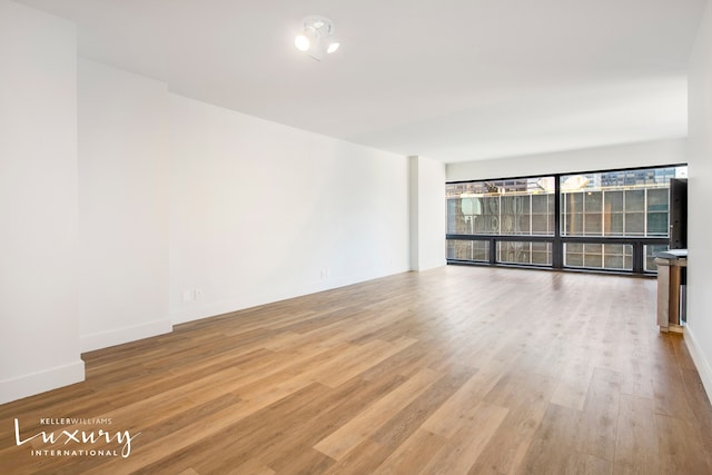 unfurnished room featuring baseboards and wood finished floors