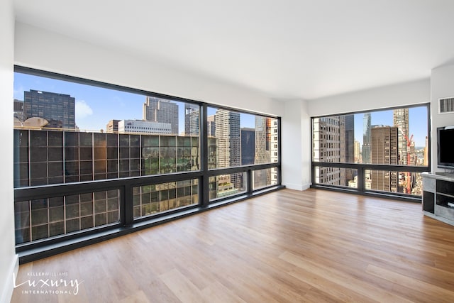 interior space with baseboards, visible vents, and wood finished floors