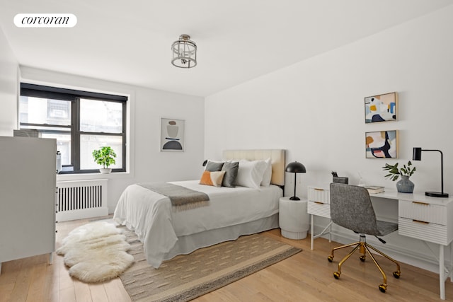 bedroom with hardwood / wood-style flooring and radiator heating unit